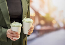 Faerch launches rPET hot drinking lid Man holding two coffee cups with sustainable lids