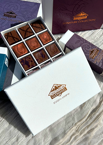 Open box of chocolates highlighting Chocolates of Glenshiel packaging